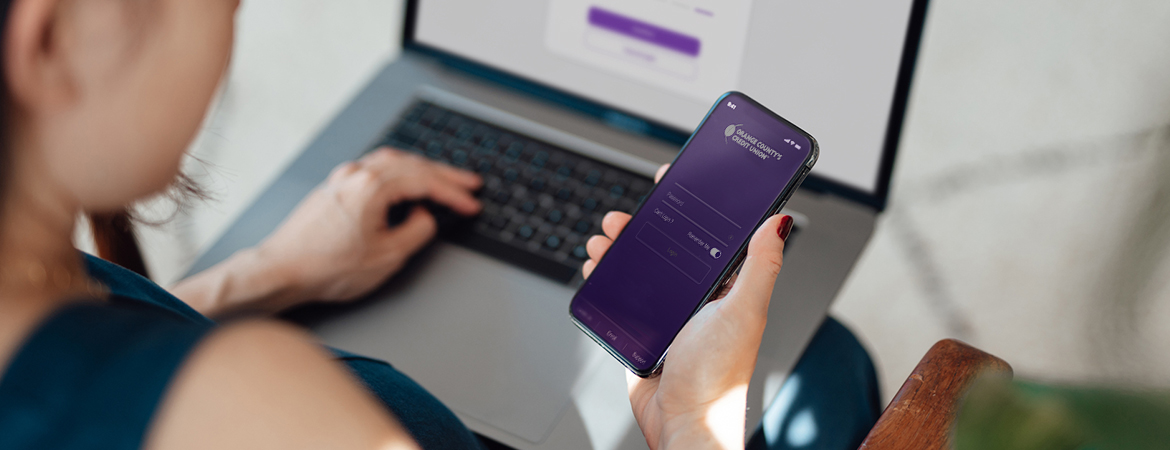 Hand holding phone with Orange County's Credit Union app
