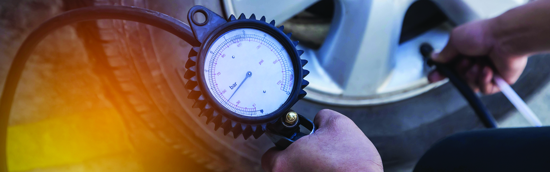 males hands checking tire pressure