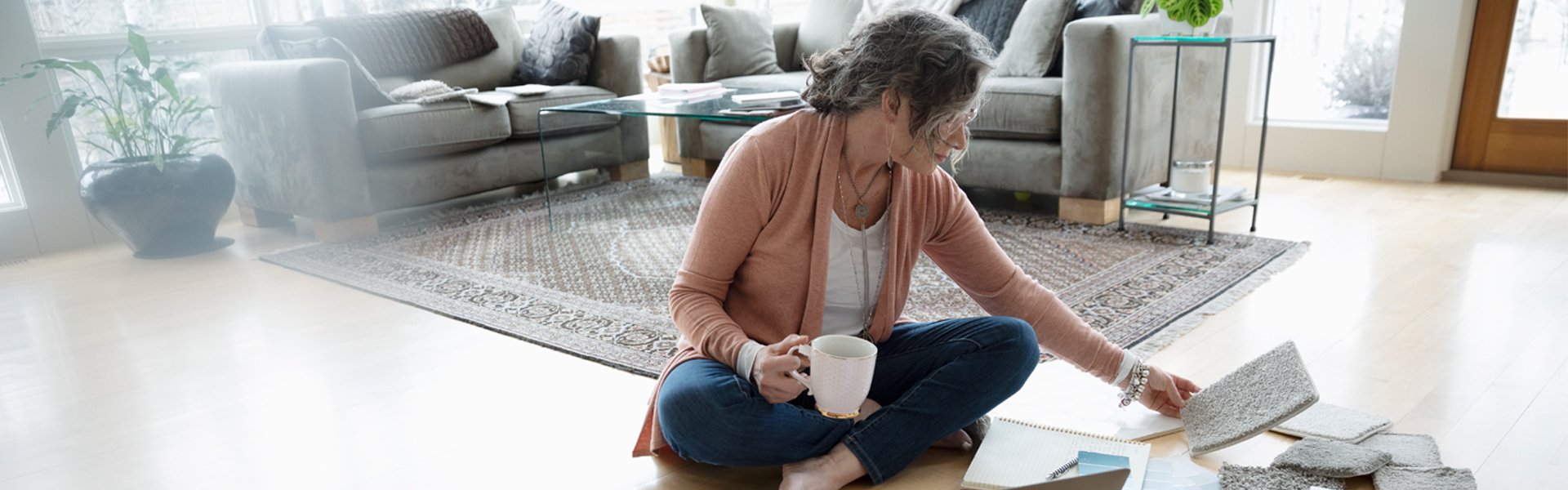 Woman on floor with laptop surrounded by papers