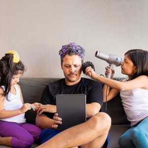 Father receiving a makeover and having nails painted by two young daughters