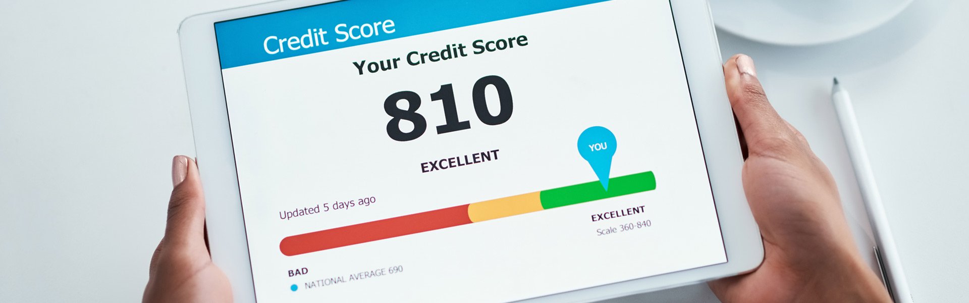 Hands holding a tablet displaying a credit score of 810