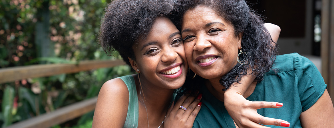 Smiling mother daughter in embrace sitting together