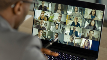 Person viewing webinar with multiple people while looking at financial portfolio charts on her tablet