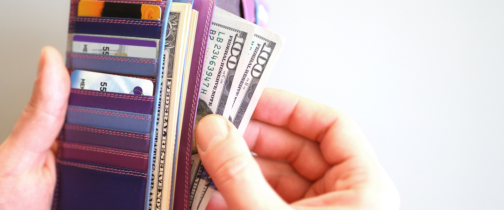 Wallet with cash and Orange County's Credit Union cards