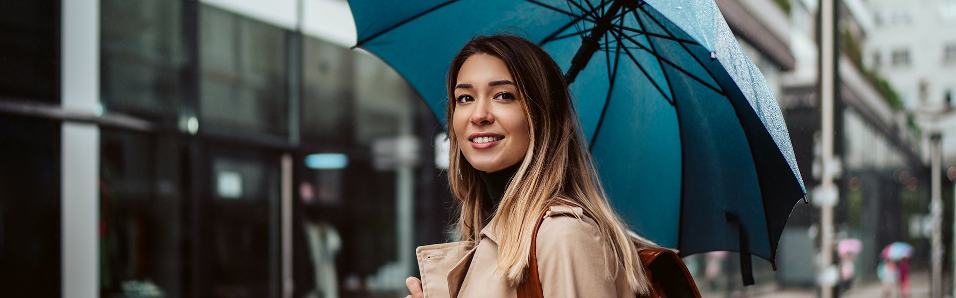 Woman holding umbrella in rainy weather