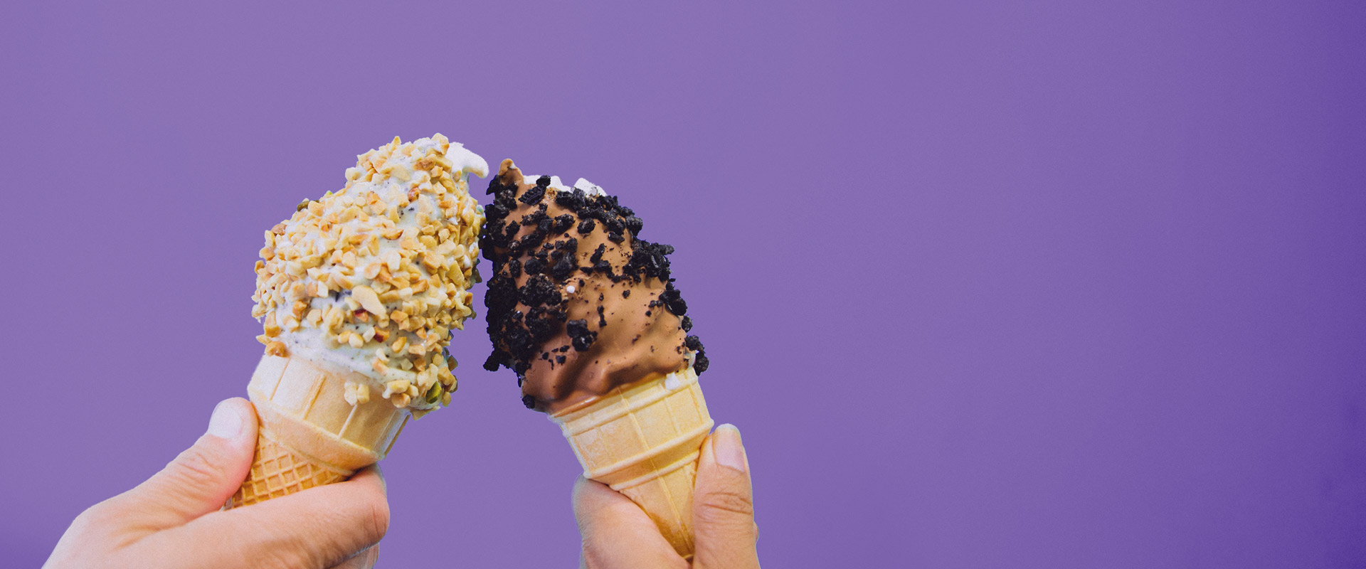 Photo of two ice cream cones held by hands