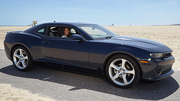 Woman in Black Sports Car on the Beach
