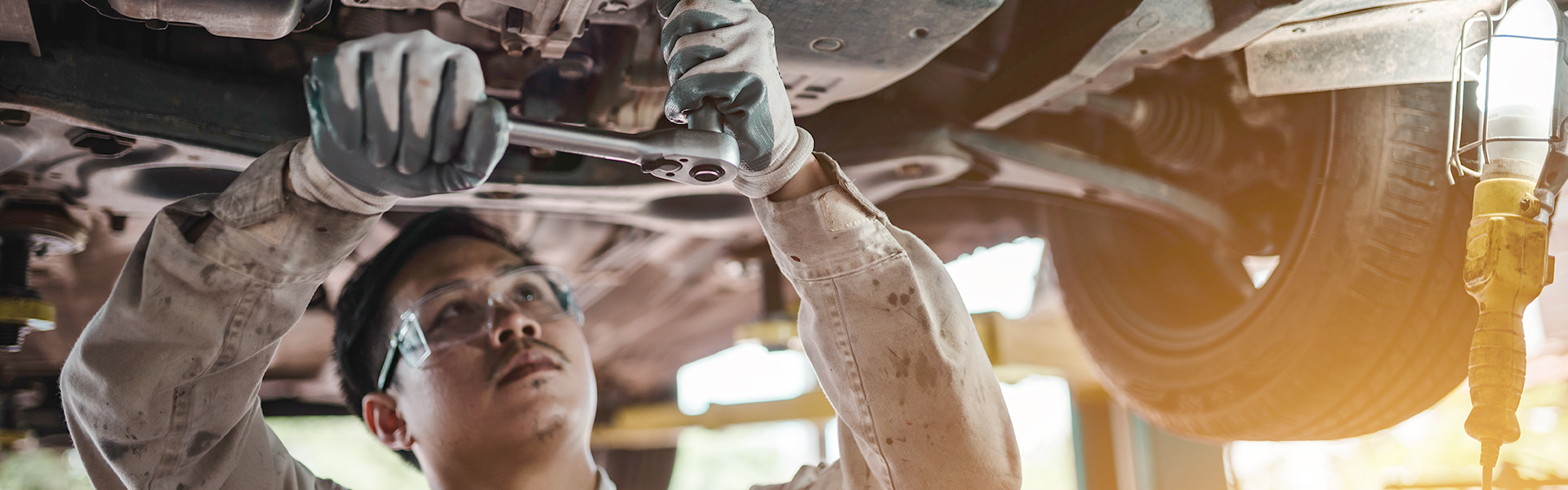 Auto mechanic working underneath a vehicle