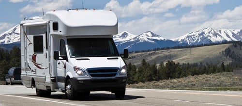 Motorhome on the road with mountains in background