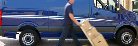 Man delivering boxes pushing a dolly