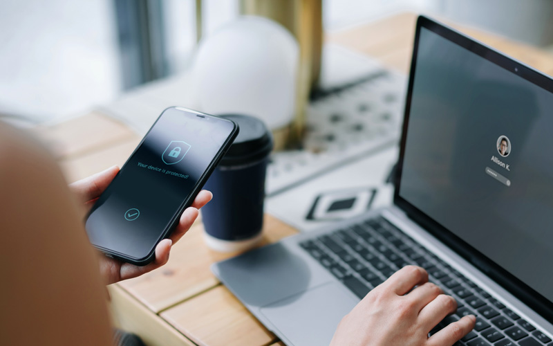 Security aware Member using their phone to do multifactor authentication of login on their laptop screen