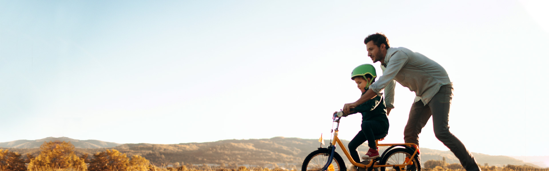 Father pushing son on bike