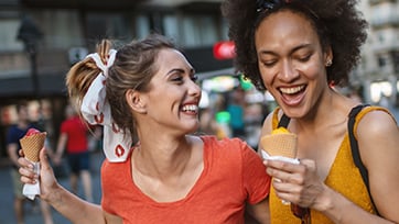 Two friends happily enjoying ice cream cones