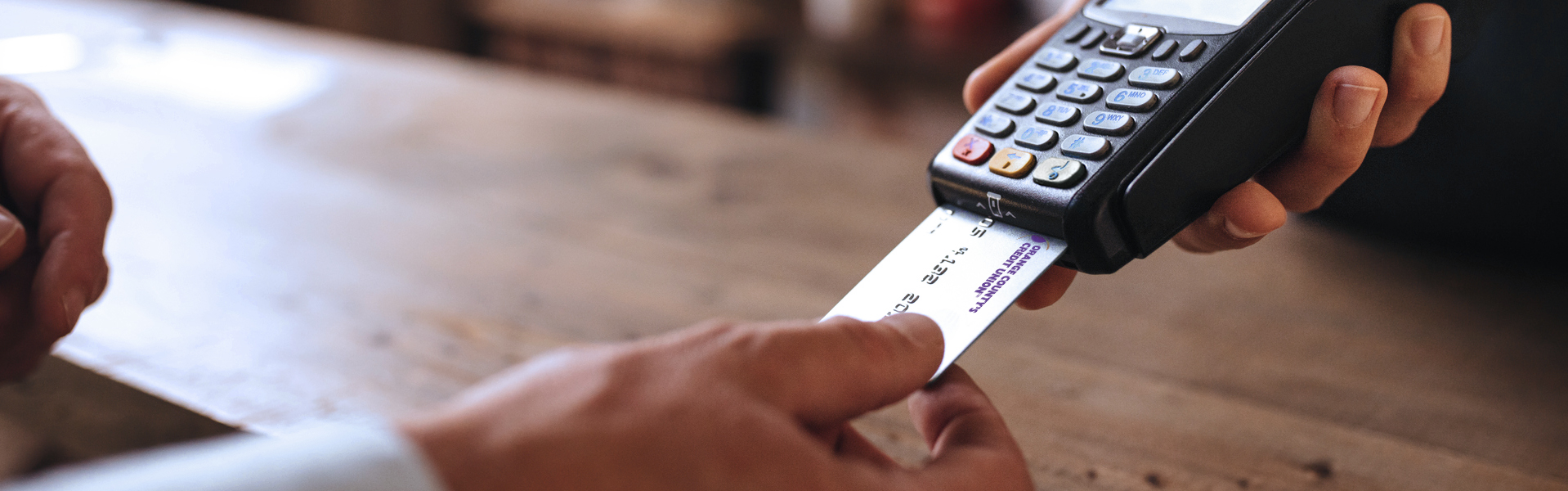 Person paying with debit card at pay station