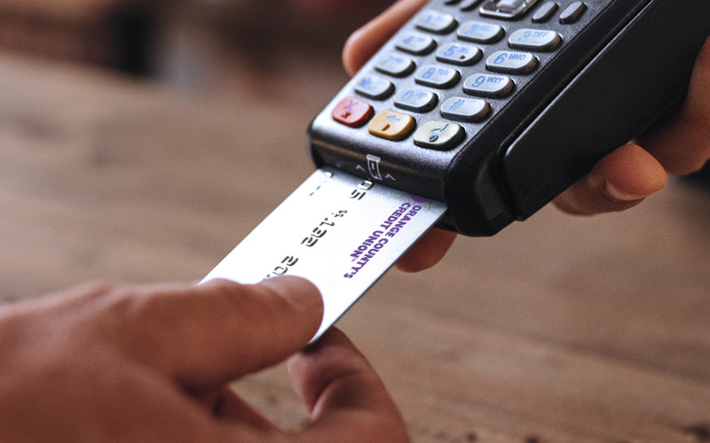 Person paying with debit card at pay station