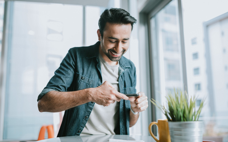 man doing banking by taking photo of a check to deposit