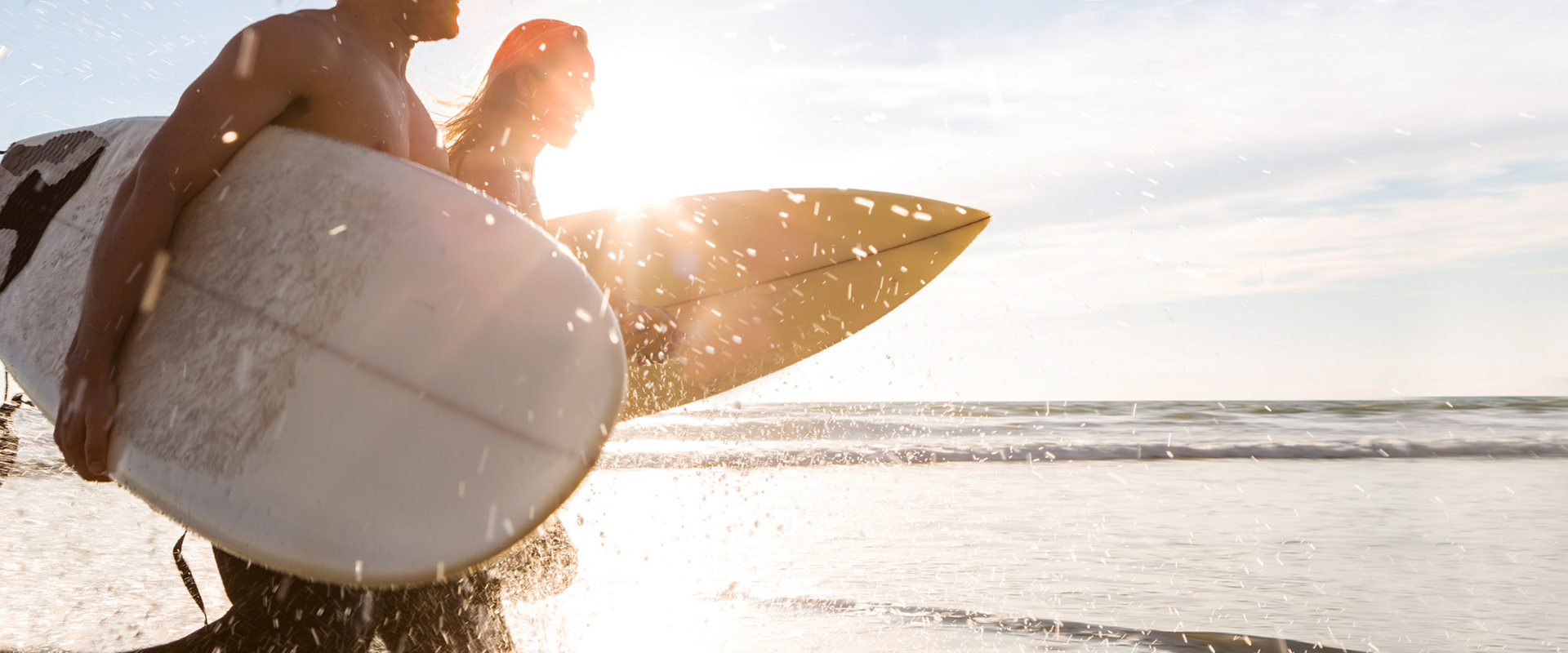 Members running on the beach with surfboards