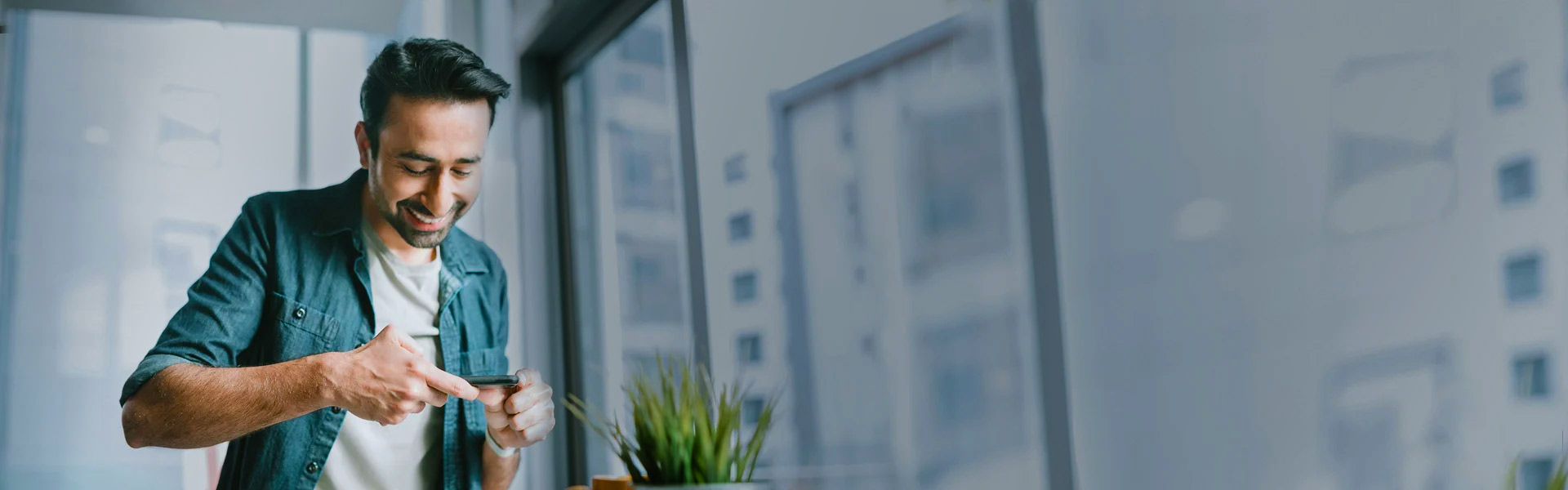 Man standing in front of a plant. Page banner.