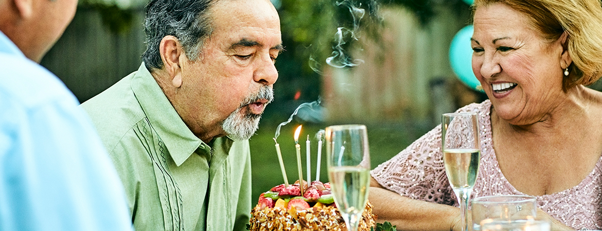 Senior man blowing out birthday candles