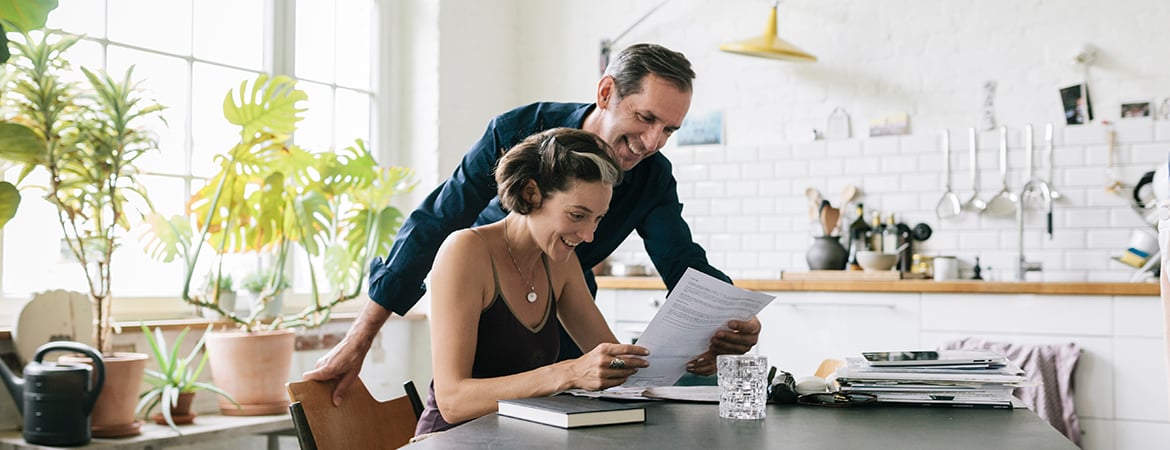 Couple excitedly looking at a document together