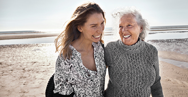 Adult daughter and senior mother enjoying a day at the beach