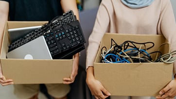 people holding boxes of electronic waste to be recycled