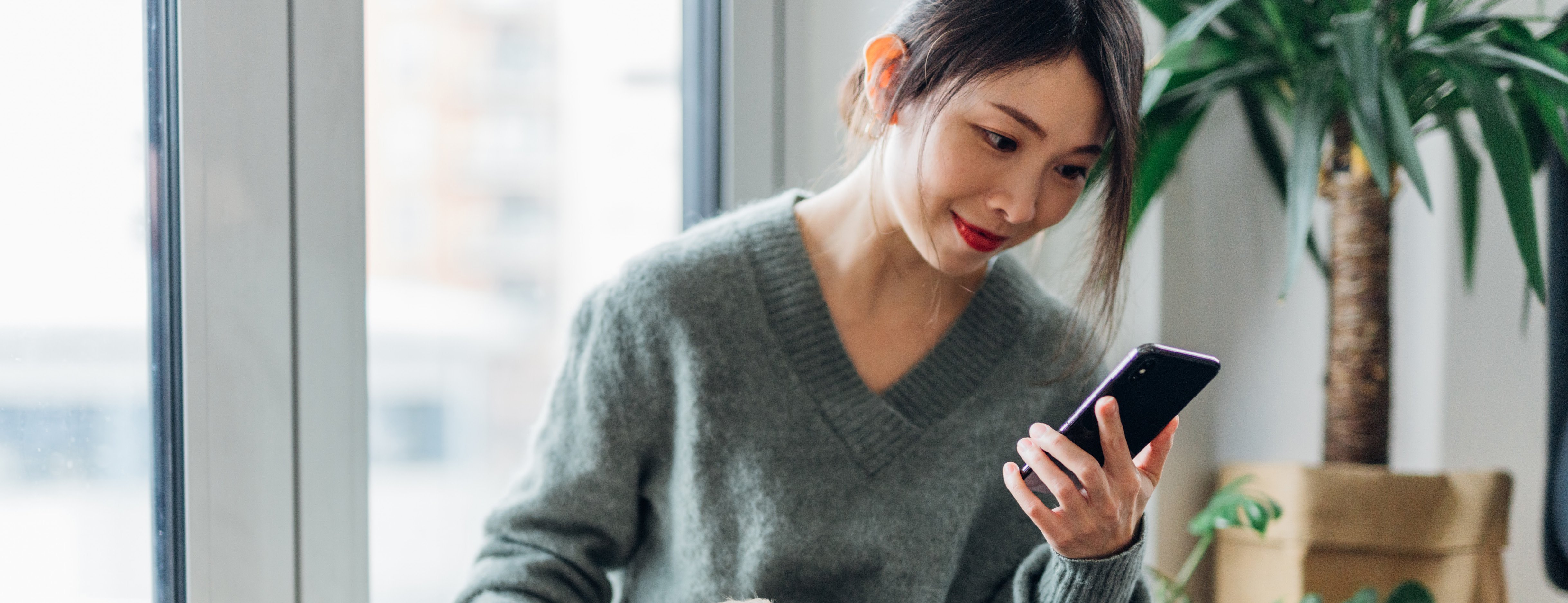 Woman looking at online banking alert on her smart phone