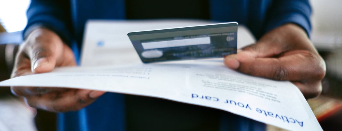 Hand holding credit card and statement