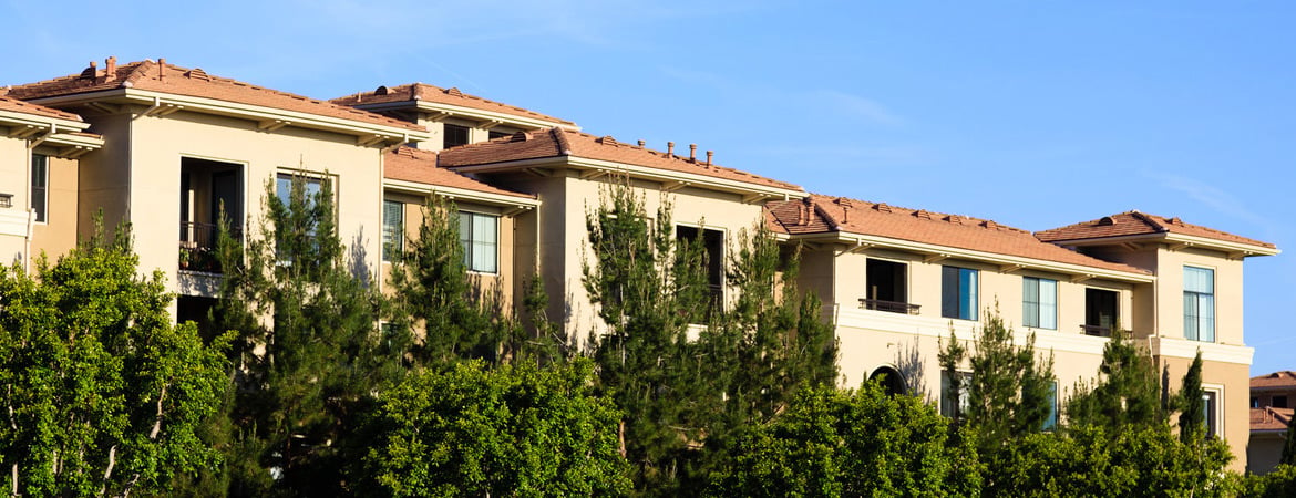 Southern California townhomes with natural flora under clear blue sky.