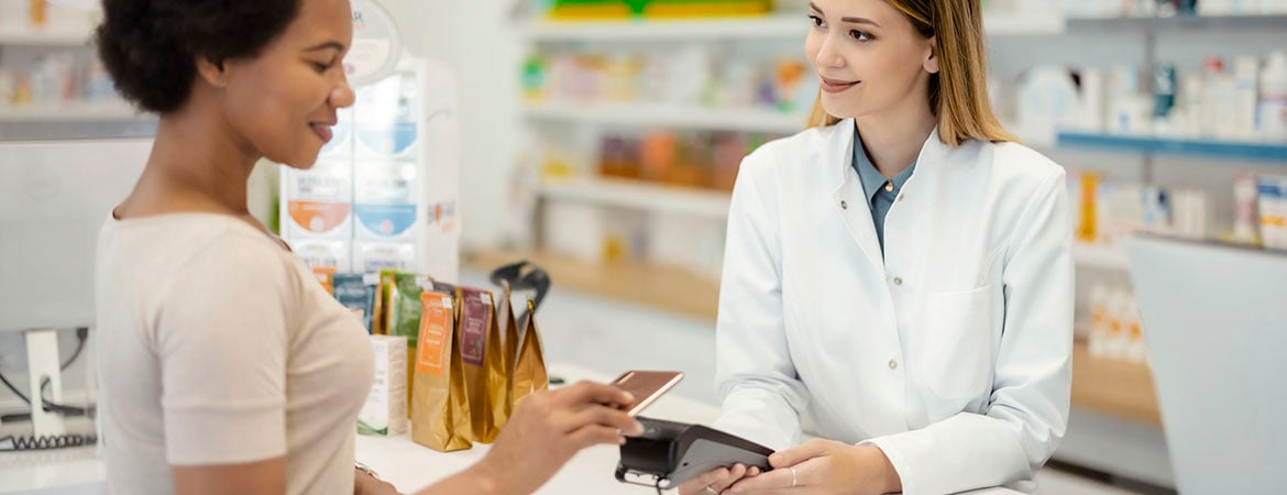Budget conscious shopper using card to tap payment at pharmacy